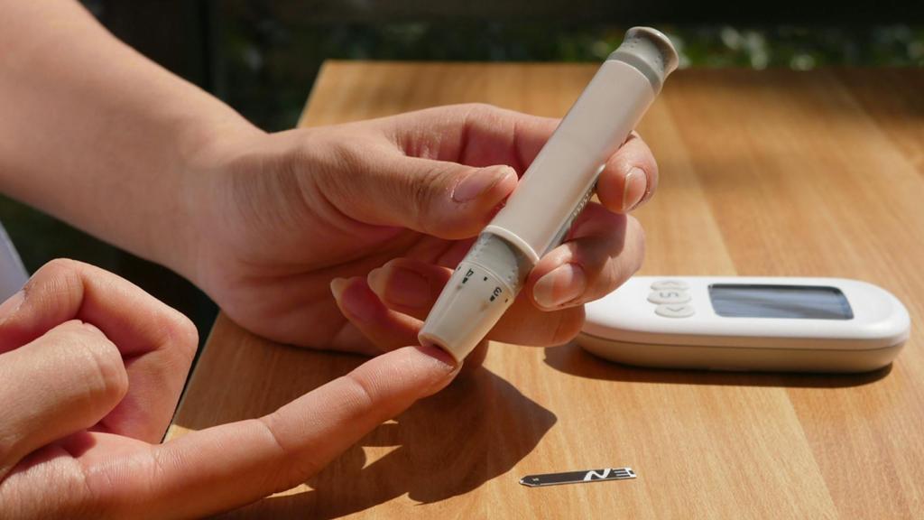 Una persona pinchándose para medir la glucosa.