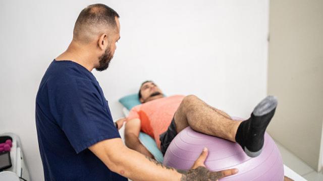Fisioterapeuta dando terapia a un hombre.