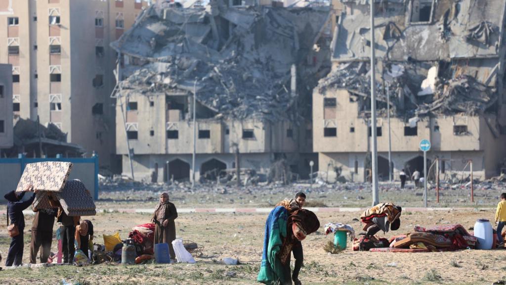 Los palestinos cargan sus pertenencias tras los ataques israelíes contra edificios residenciales en la ciudad de Hamad, en Khan Younis.