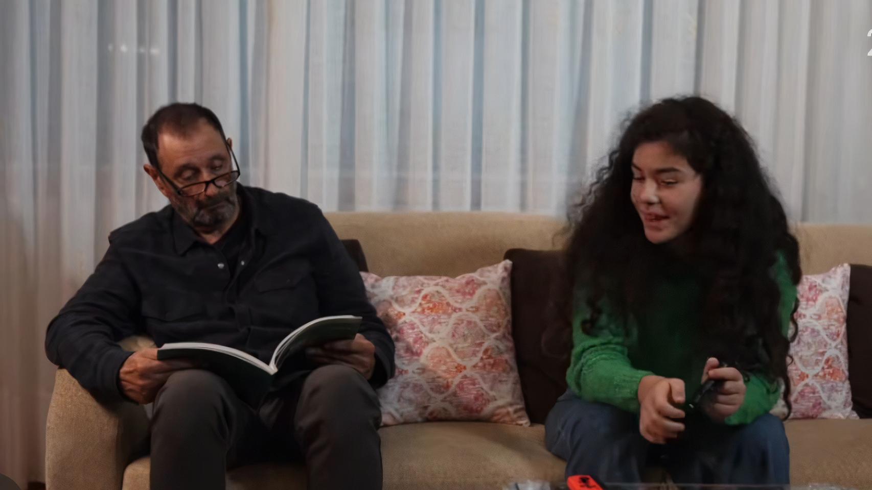 La nieta y el abuelo hablan en el salón.