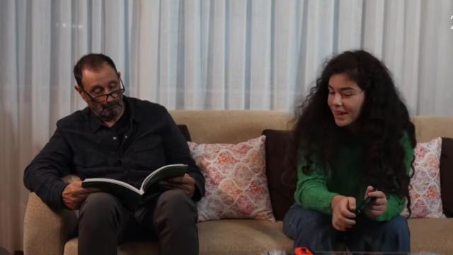 La nieta y el abuelo hablan en el salón.