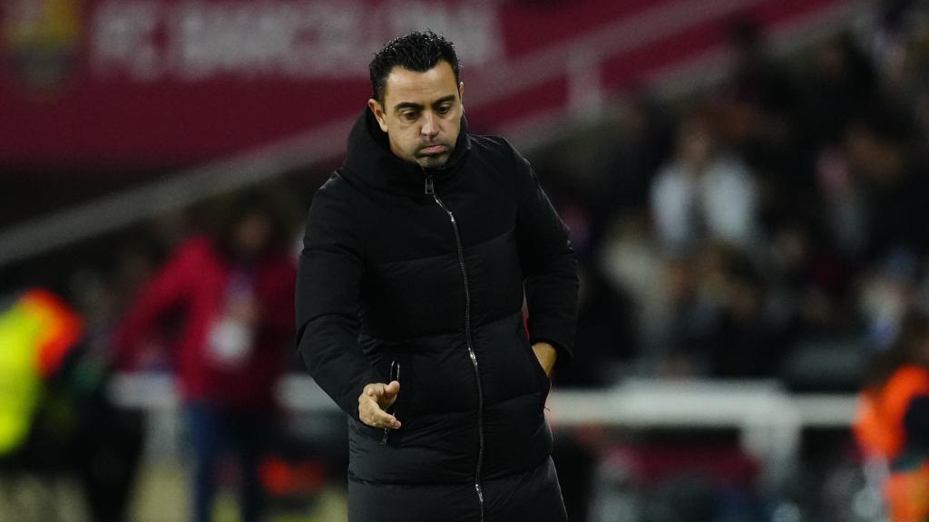 Simeone, de fondo, y Xavi, durante el Barcelona - Atlético de Madrid