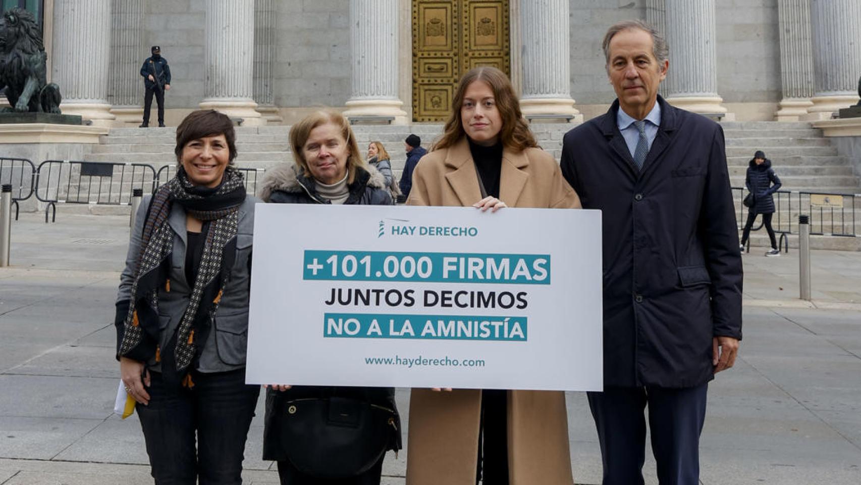 Representantes de la fundación Hay Derecho posan este martes ante la Puerta de los Leones del Congreso de los Diputados.