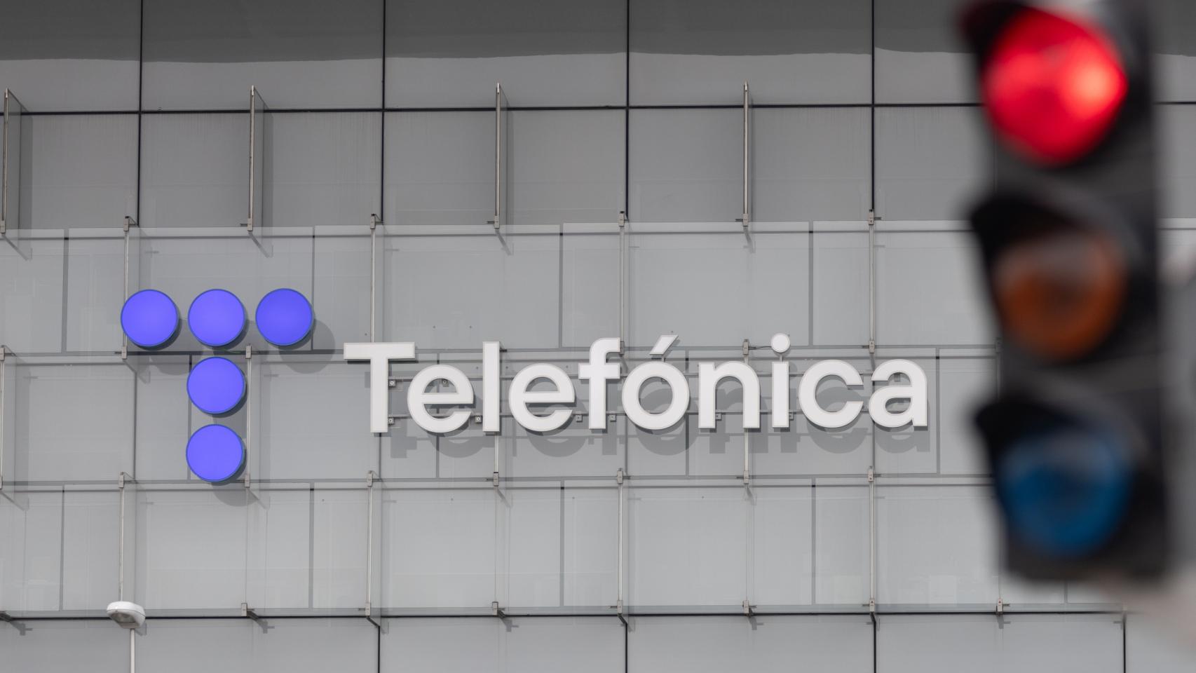 Un semáforo en rojo frente a la sede de Telefónica en Madrid.