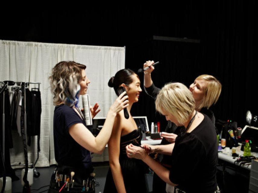 Estilistas y modelo backstage de un desfile.