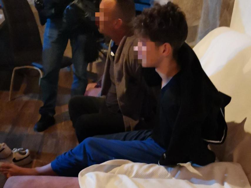 Imagen de la detención durante la operación. El padre y su hijo menor de edad, engrilletados a la espalda.