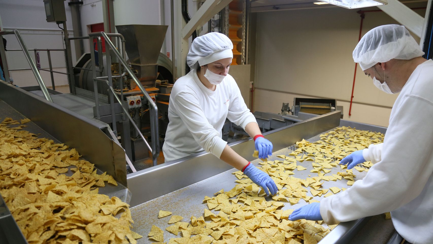 Imagen de dos trabajadores en la planta que Ibersnacks tiene en Medina del Campo (Valladolid).