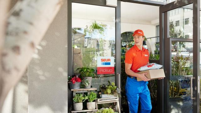 Un trabajador de SEUR reparte un paquete.
