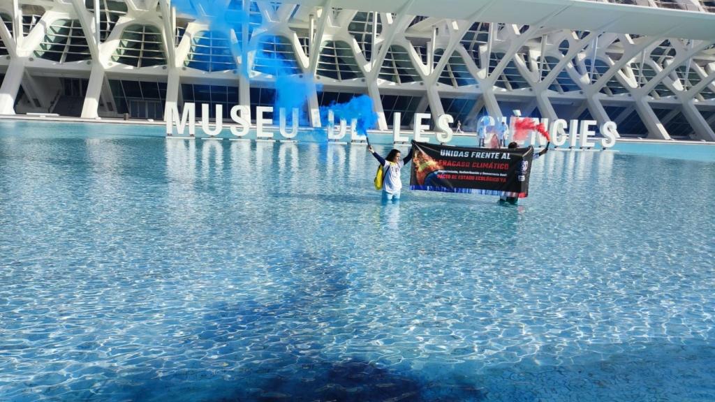 Científicos tiñen de negro un estanque de les Arts i les Ciències para denunciar que la COP28 es un fracaso climático.