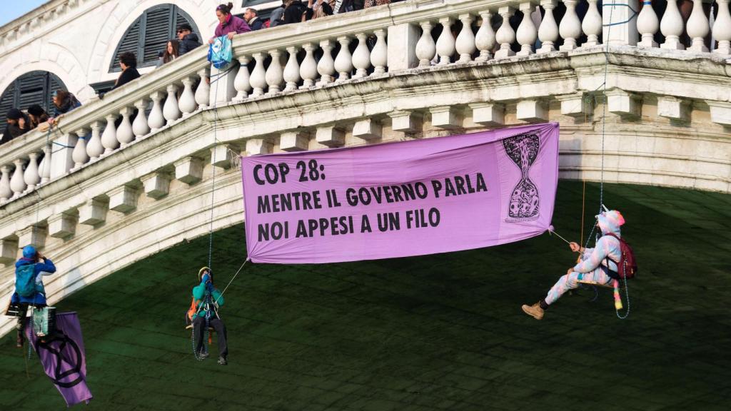 La gente cuelga una pancarta sobre el Gran Canal durante una protesta de activistas climáticos de la 'Rebelión de Extinción' en Venecia, Italia.