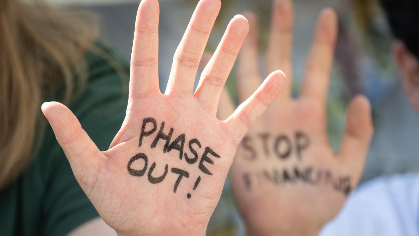 Activistas climáticos han escrito ¡Phase Out! y Stop Financing en sus manos durante una protesta en la COP28, 9 de diciembre de 2023.