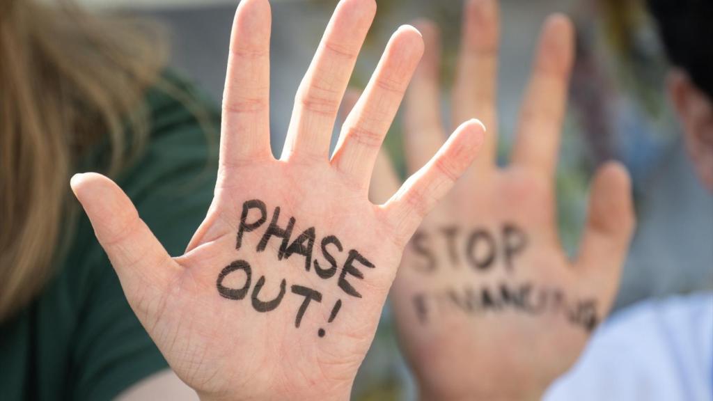 Activistas climáticos han escrito ¡Phase Out! y Stop Financing en sus manos durante una protesta en la COP28, 9 de diciembre de 2023.