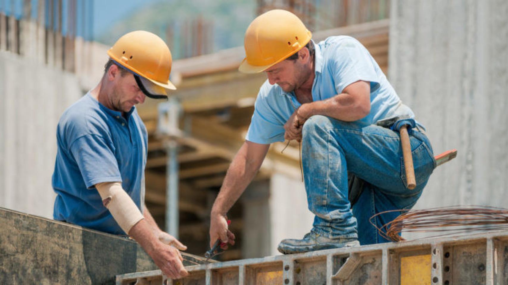 Dos empleados realizando trabajos en una construcción