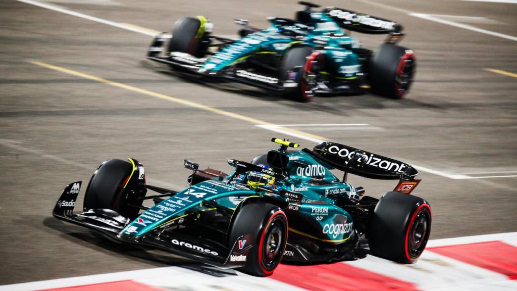 Fernando Alonso y Lance Stroll compiten por una posición en una carrera.