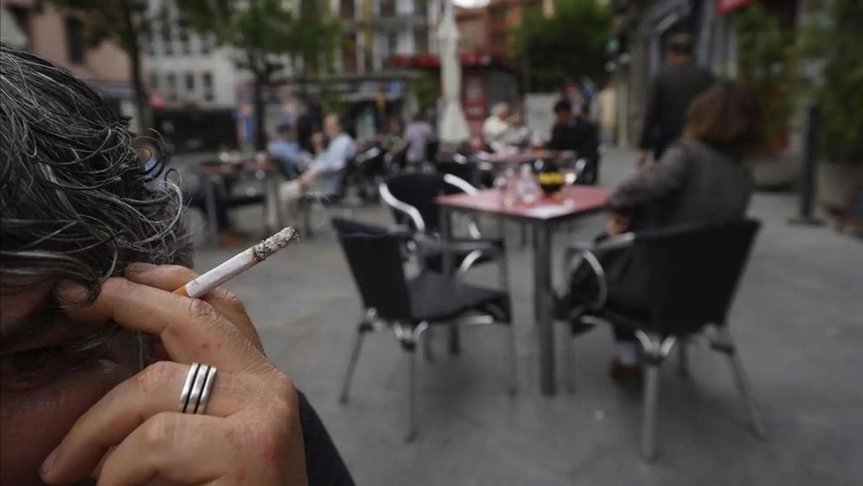 Imagen de archivo de una mujer fumando en una terraza.
