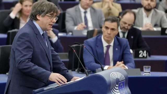 El expresidente de la Generalitat, Carles Puigdemont, y de fondo el presidente del Gobierno, Pedro Sánchez, en el pleno del Parlamento Europeo.