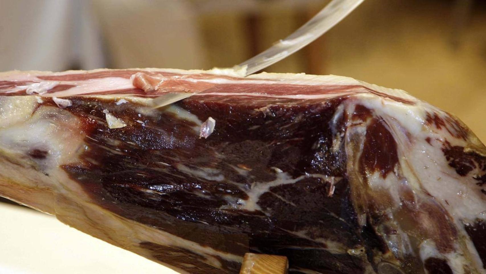 Una persona cortando jamón.