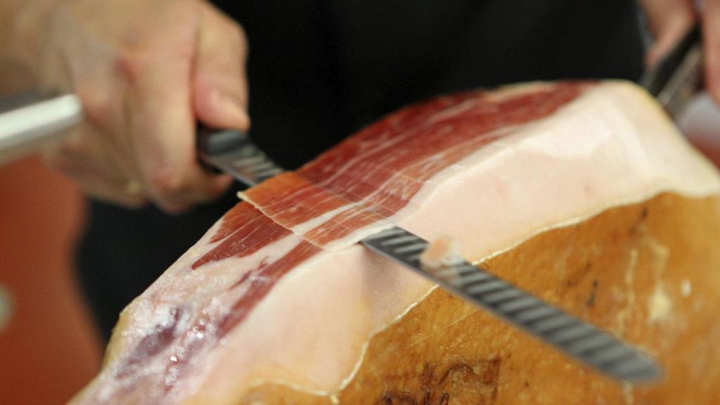 Una persona cortando jamón.