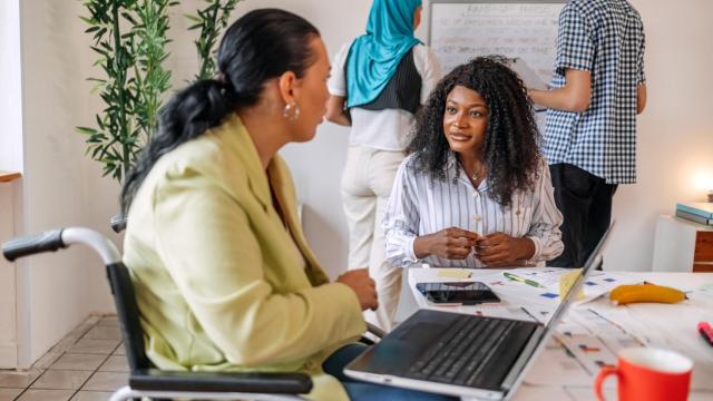 Imagen de archivo de una ejecutiva tutorizando a otra mujer.