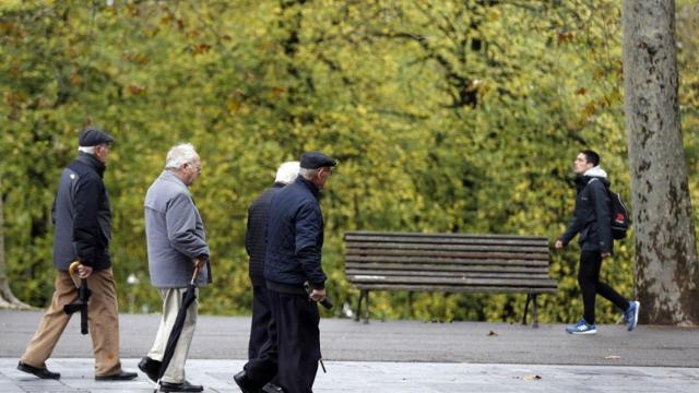 Varias personas de avanzada edad caminando por la calle.