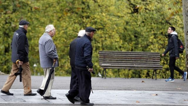 Varias personas de avanzada edad caminando por la calle.