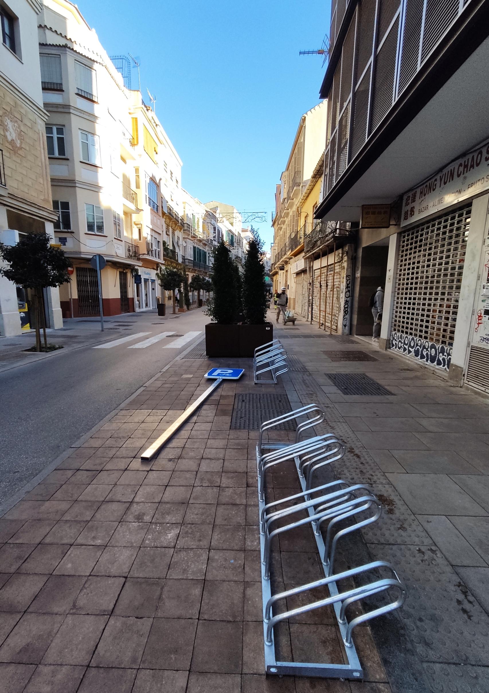 Imagen de un aparcabicis y una señal de tráfico antes de ser instalada en la calle Carretería.