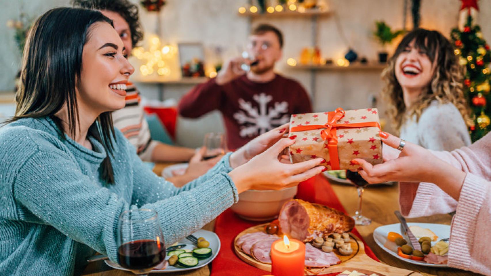 Mujer recibiendo un regalo en una celebración navideña.
