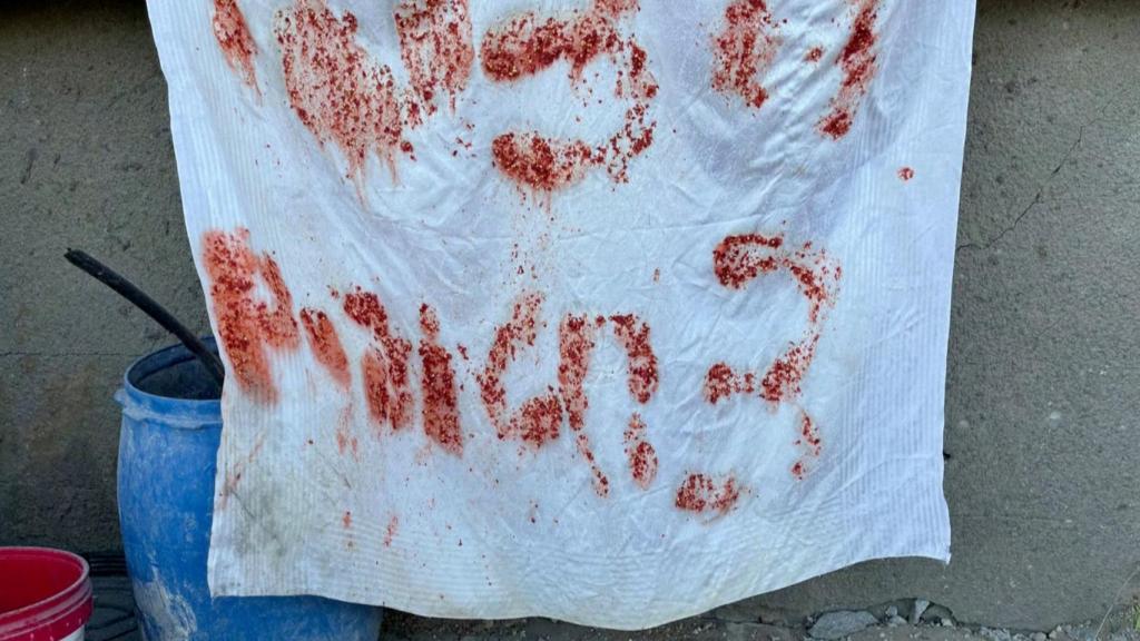 Cartel en hebreo anunciando tres rehenes en el edificio de Gaza donde acabaron con ellos