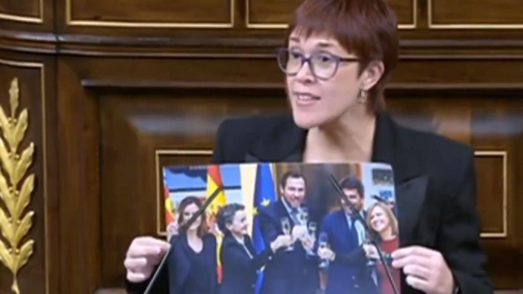 Águeda Micó sostiene una foto de Óscar Puente brindado por el pacto del Puerto de Valencia