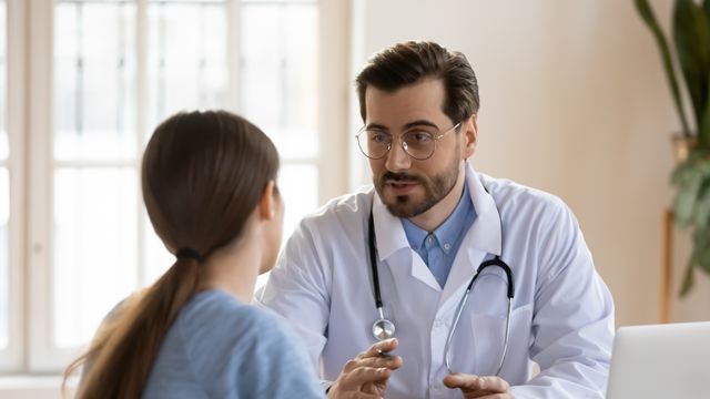 Un médico atiende a una paciente en la consulta.