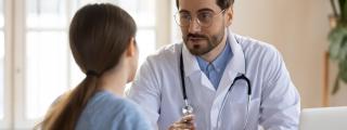 Un médico atiende a una paciente en la consulta.