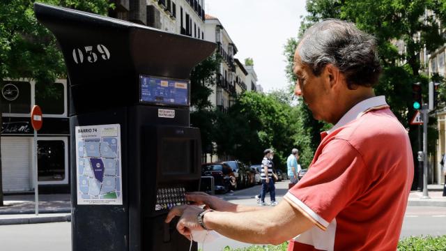 Un hombre utiliza el parquímetro del Servicio de Estacionamiento Regulado (SER) de Madrid.