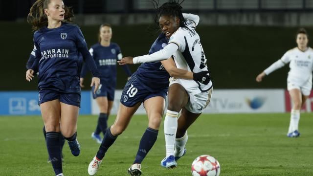 La delantera del Real Madrid Naomie Feller (d) trata de escapar de Thea Greboval (c), del París FC.