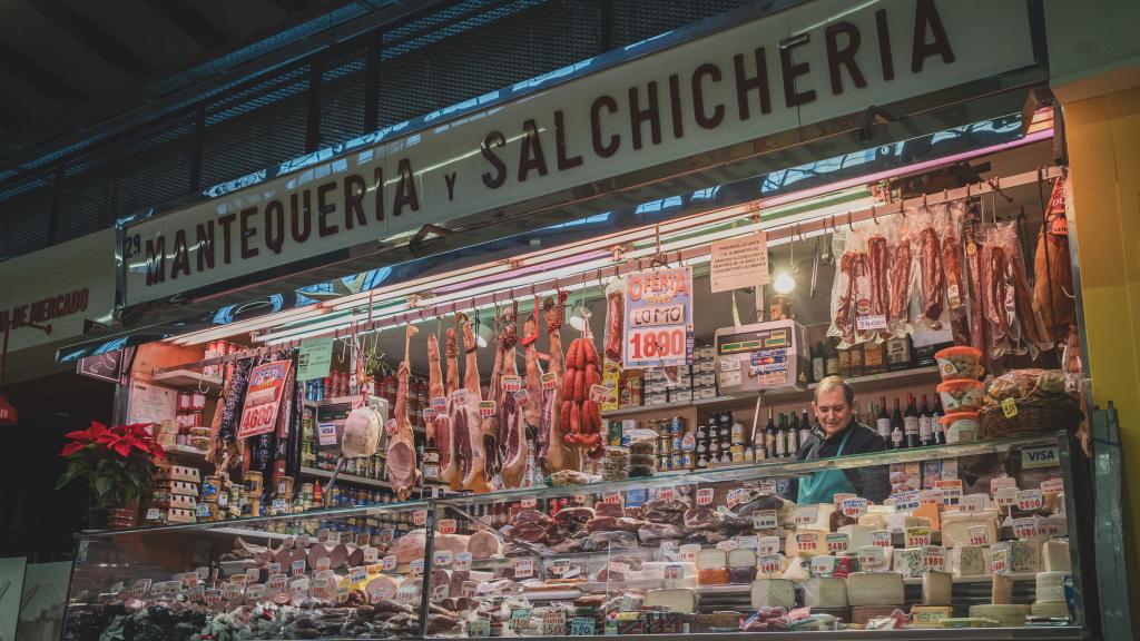 El charcutero preparando pedidos en su puesto de mercado.