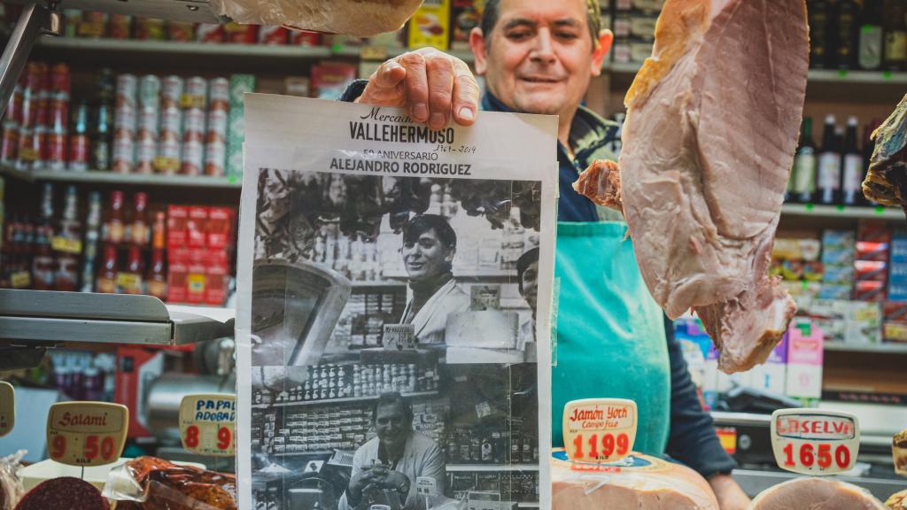 El charcutero Alejandro muestra fotografías de él antiguas.