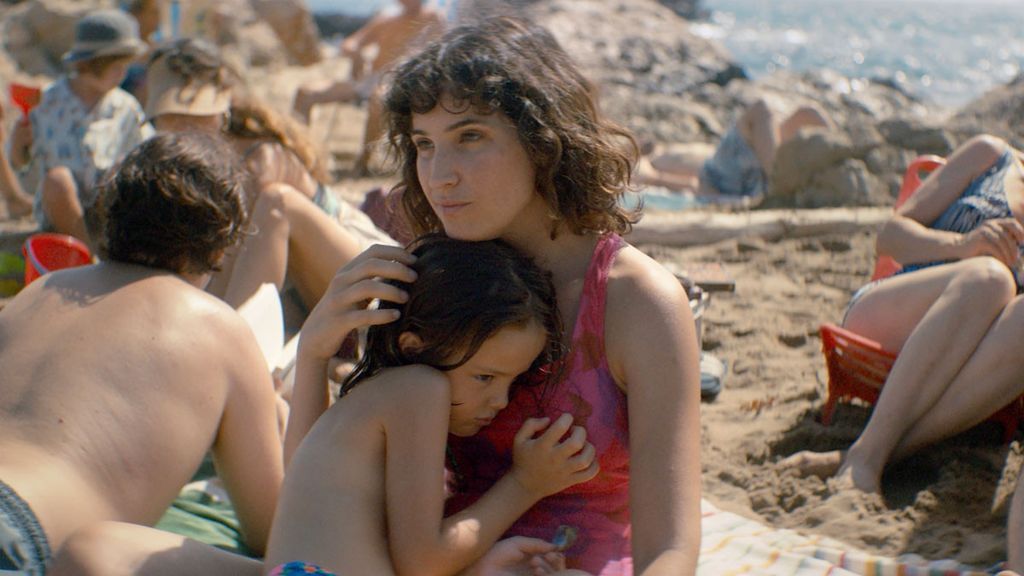 Mila, de niña, abrazada a su madre.