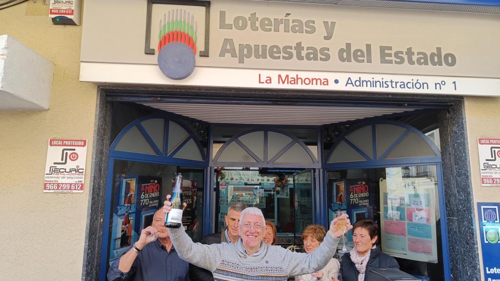 El lotero de la Administración La Mahoma celebra el tercer premio.