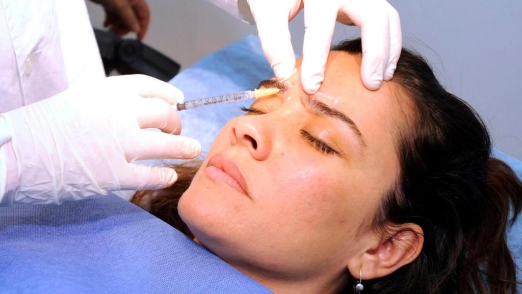 Una mujer recibe una inyección de bótox en el entrecejo.