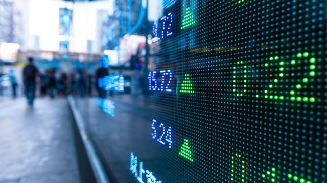 Una pantalla que se ve desde la calle muestra la cotización de varios valores.