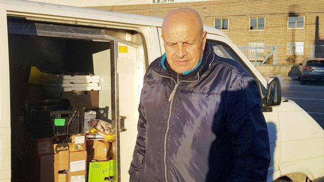 Carlos De la Fuente junto a su furgoneta solidaria llena de víveres para distribuir