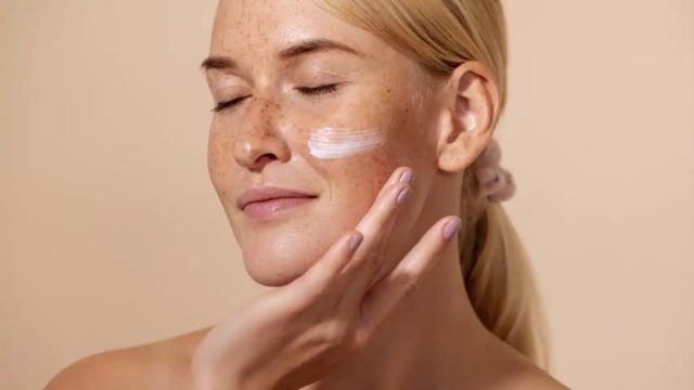 Una mujer, aplicando su crema.