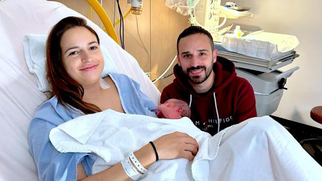 Chloe en brazos de su madre y acompañada por su padre en el hospital de Elche.