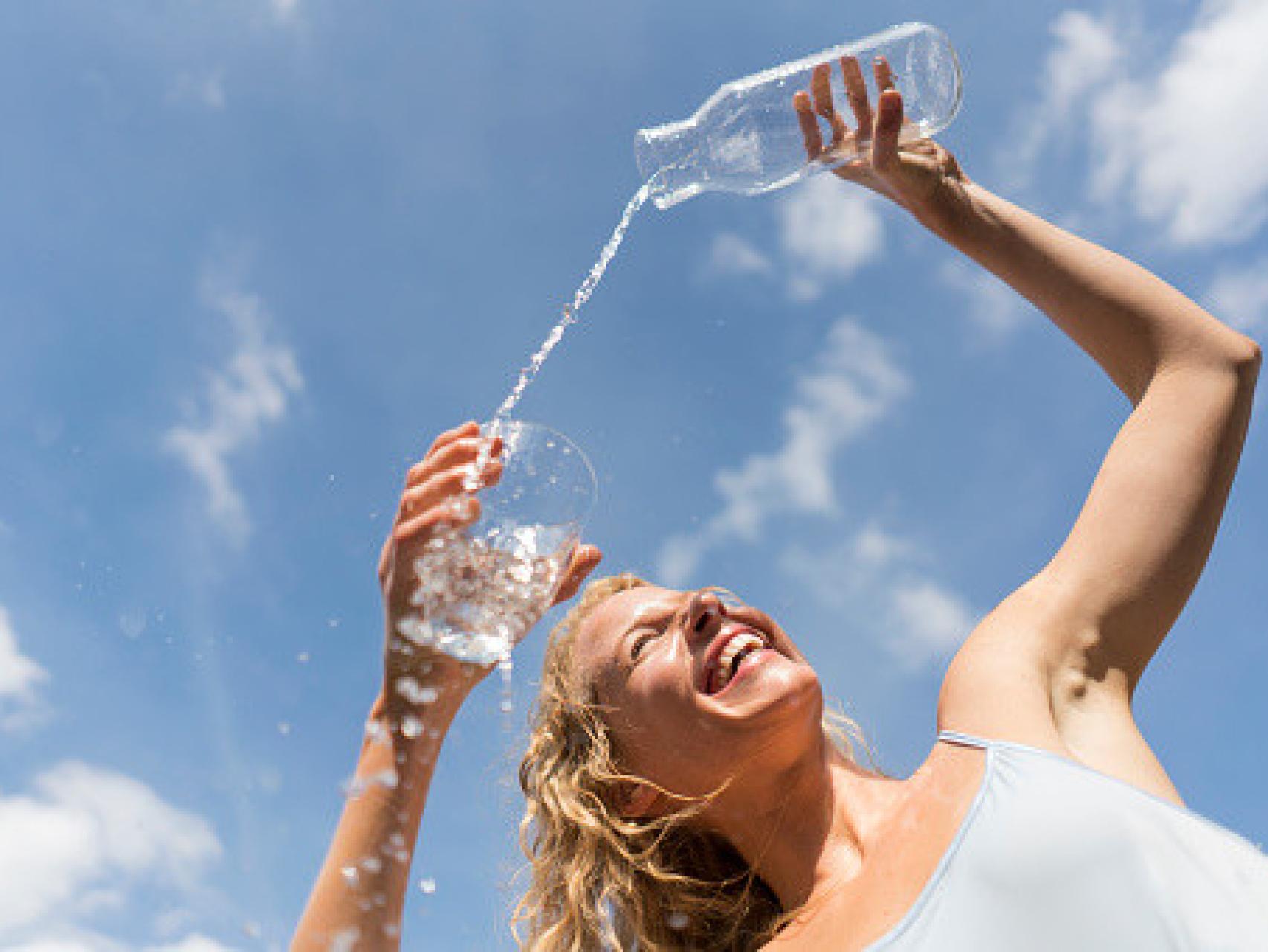 Una mujer echándose agua.