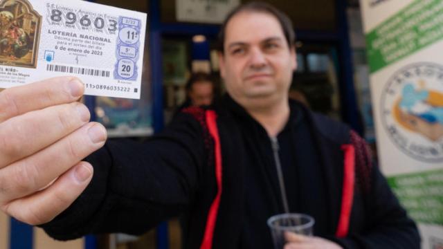 Una persona con un décimo galardonado en la Lotería del Niño 2023