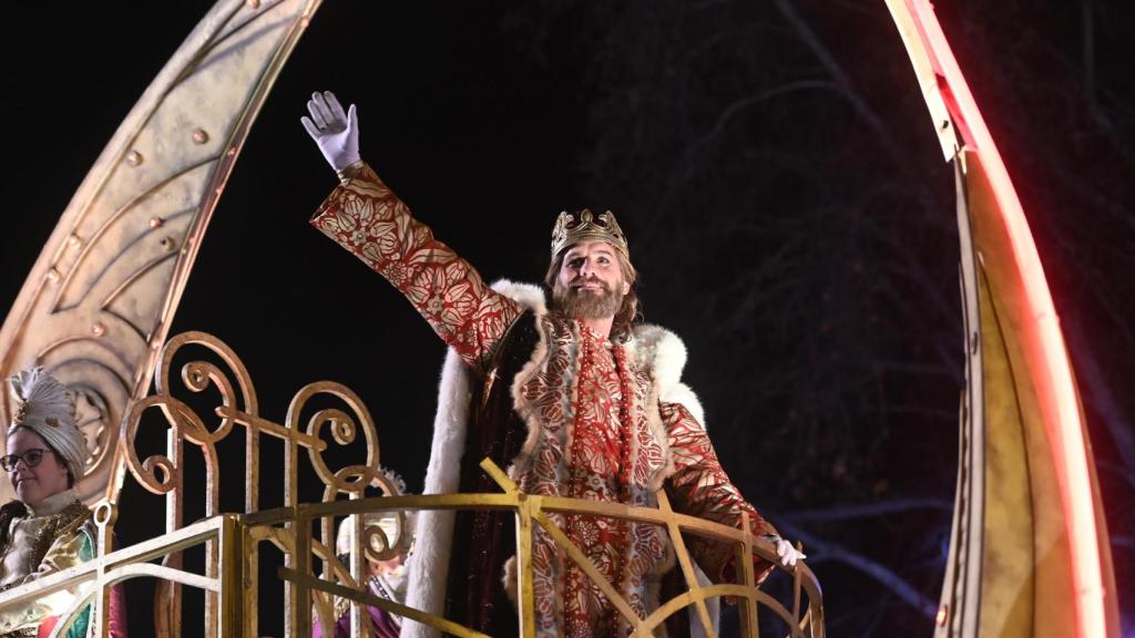 El Rey Gaspar saluda a los niños durante la cabalgata.