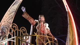 El Rey Gaspar saluda a los niños durante la cabalgata.