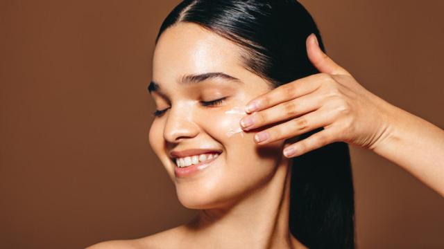Una mujer, aplicando su crema.