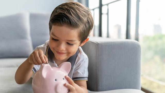 Imagen de un niño metiendo monedas en la hucha