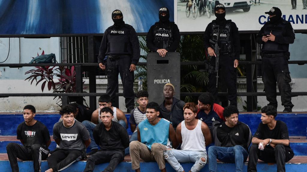Efectivos de la Policía Nacional de Ecuador custodian a un grupo de detenidos en Guayaquil.