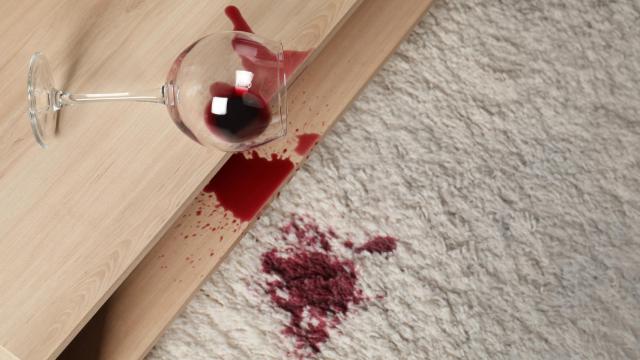 Una copa de vino derramada sobre una alfombra.
